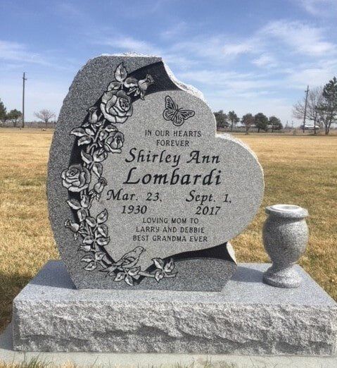 Black granite upright shaped like a curled page, etched with a music scene and a passage of text