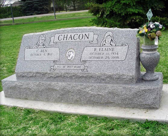 Grey granite slant with scrollwork, two etched figures and a porcelain cameo, on a rock pitched base
